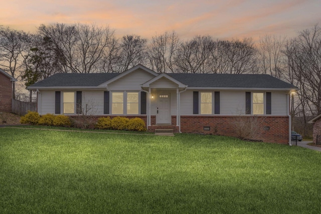 ranch-style home featuring crawl space, brick siding, a yard, and roof with shingles