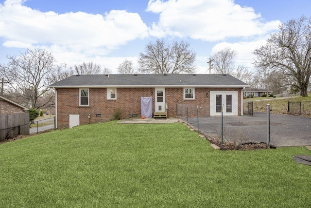 rear view of property featuring a patio, brick siding, french doors, a lawn, and crawl space