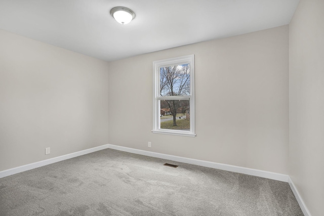 carpeted empty room with baseboards