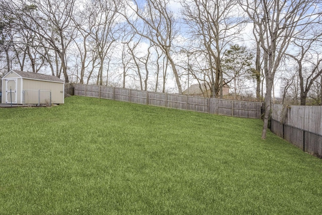 view of yard featuring an outbuilding, a storage unit, and a fenced backyard