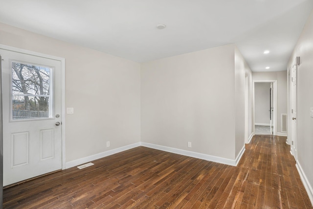 spare room featuring dark wood-style floors, recessed lighting, visible vents, and baseboards