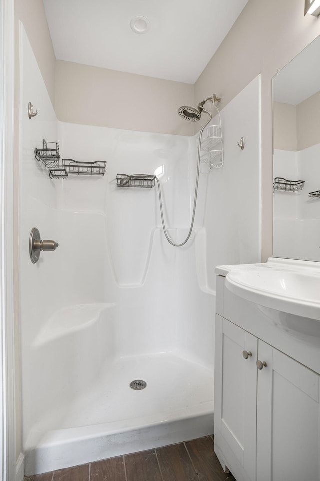 full bath with a shower, wood finished floors, and vanity