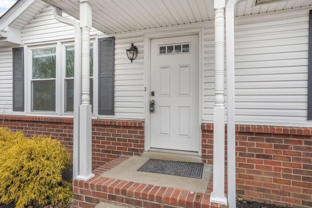 doorway to property with brick siding