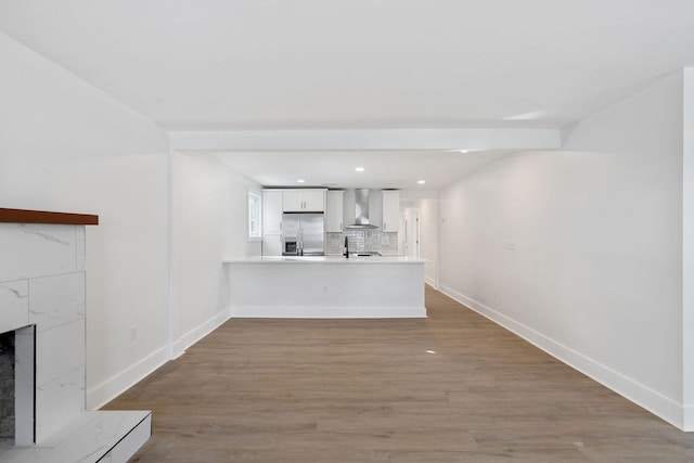 unfurnished living room with wood finished floors, baseboards, recessed lighting, a sink, and a tile fireplace