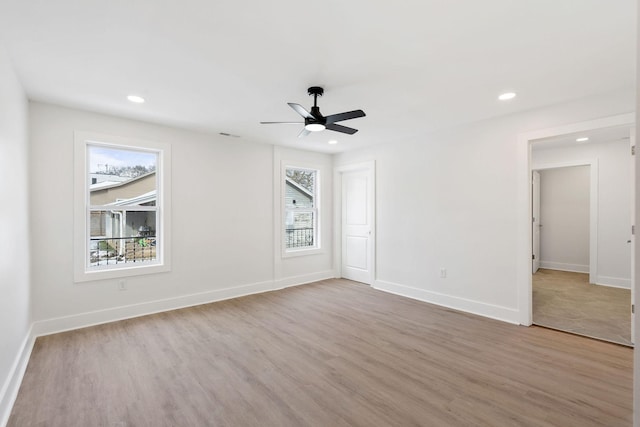 spare room featuring recessed lighting, light wood-type flooring, and baseboards