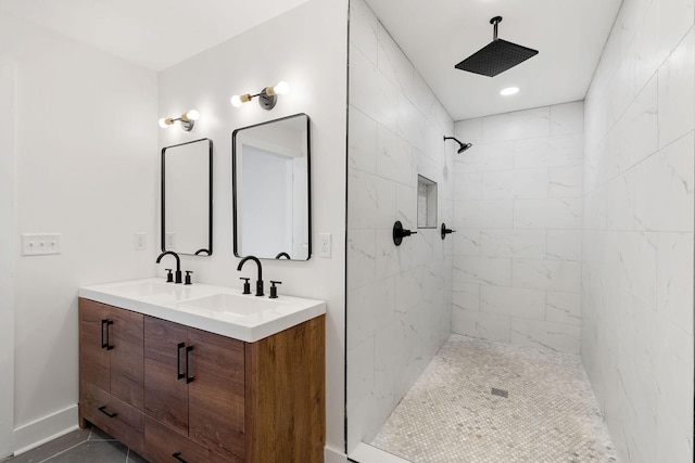 full bathroom featuring double vanity, tiled shower, baseboards, and a sink