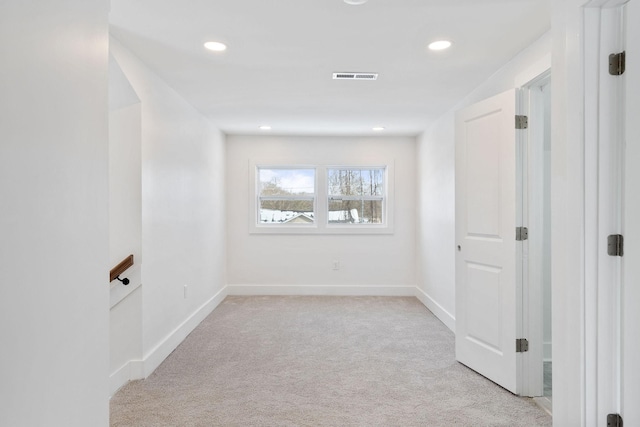 empty room with recessed lighting, visible vents, light colored carpet, and baseboards