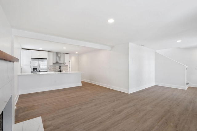 unfurnished living room featuring a sink, wood finished floors, and recessed lighting