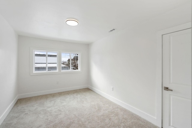 carpeted empty room with visible vents and baseboards