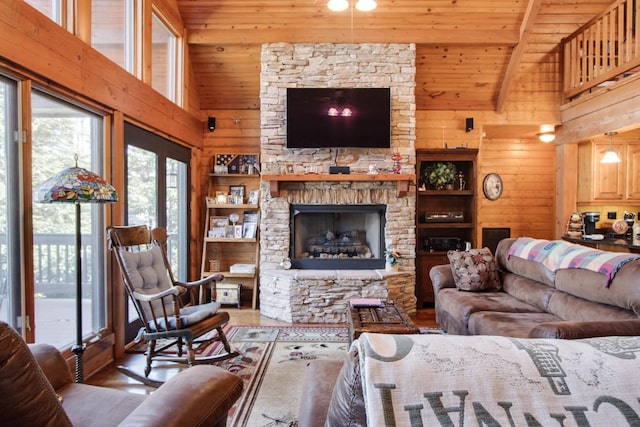 living area featuring wood ceiling, wood walls, a stone fireplace, high vaulted ceiling, and beamed ceiling