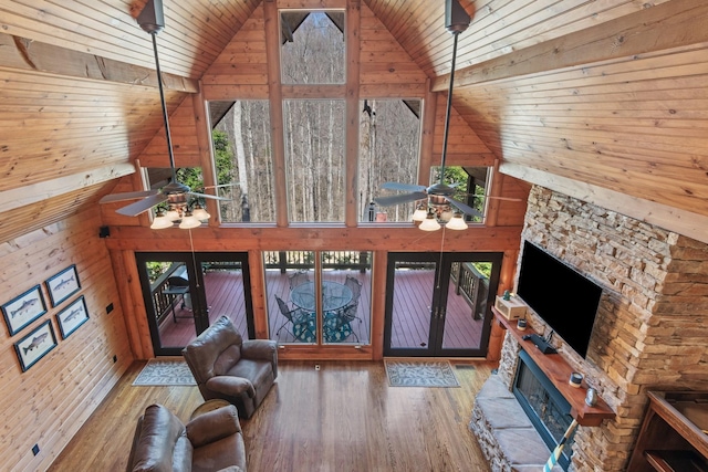 unfurnished living room with wooden ceiling, wood finished floors, a ceiling fan, and high vaulted ceiling