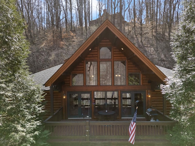 exterior space featuring log siding and a shingled roof