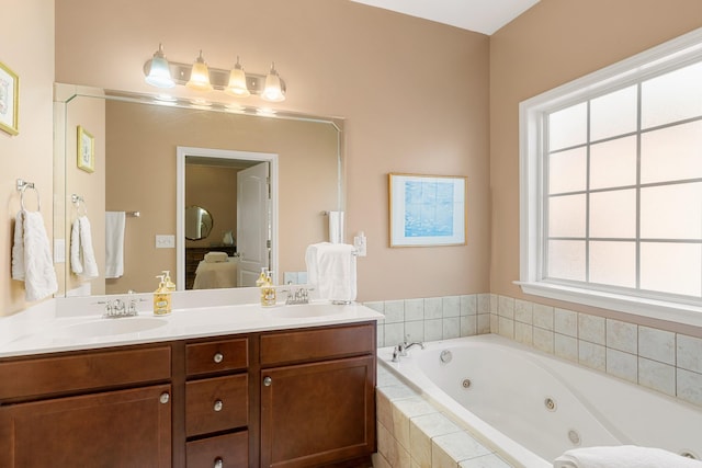 ensuite bathroom featuring double vanity, a sink, a tub with jets, and ensuite bathroom