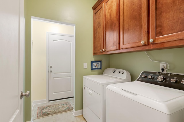 washroom featuring cabinet space, light tile patterned floors, baseboards, and washer and dryer