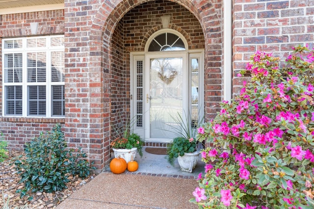 property entrance featuring brick siding