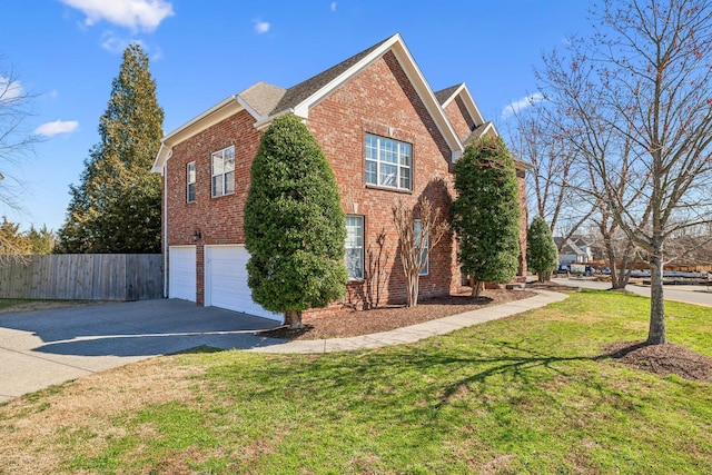 view of side of home with fence, driveway, a garage, a lawn, and brick siding