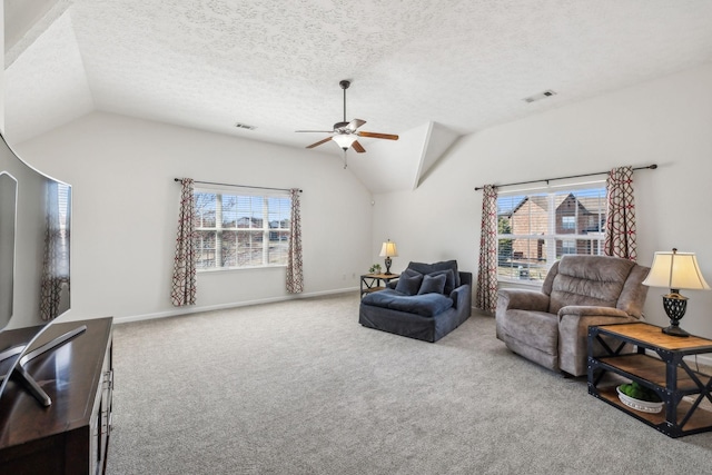 carpeted living room featuring visible vents, plenty of natural light, and vaulted ceiling