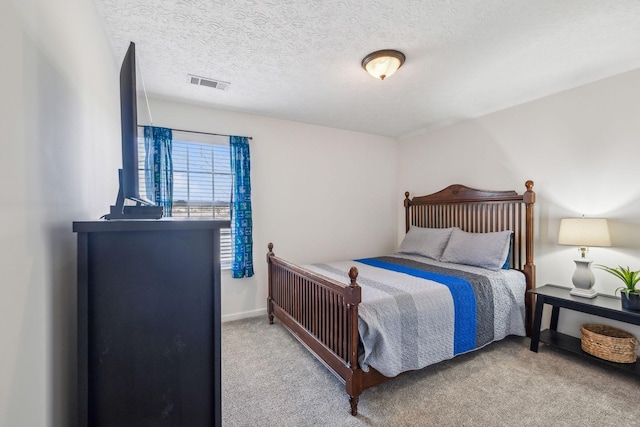 bedroom with visible vents, a textured ceiling, baseboards, and carpet floors