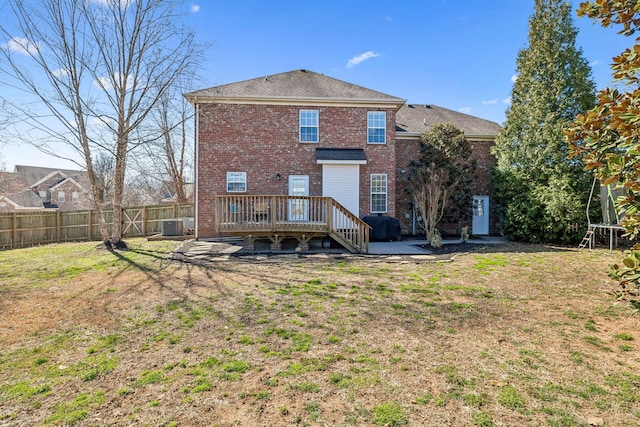 back of house with a patio, fence, a wooden deck, a lawn, and brick siding