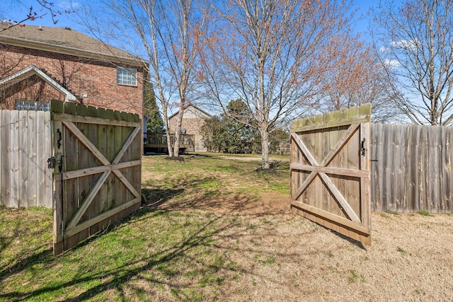 view of yard with fence and a gate