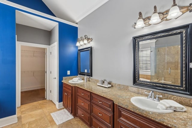 bathroom featuring a sink, vaulted ceiling, a spacious closet, double vanity, and a stall shower