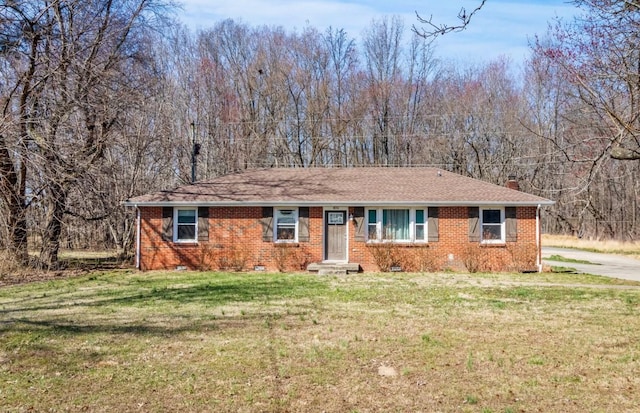 ranch-style home featuring roof with shingles, a front yard, crawl space, brick siding, and a chimney