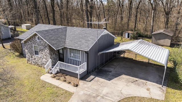 view of front of house featuring stone siding, driveway, a front lawn, and a storage unit