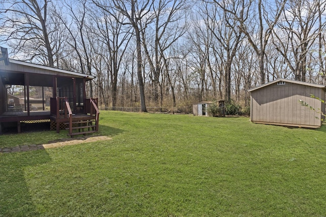 view of yard featuring an outbuilding, a sunroom, and a storage unit