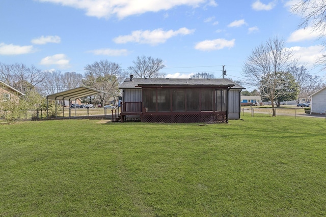 back of property featuring a carport, a lawn, fence, and a sunroom