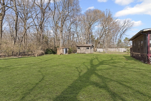 view of yard featuring an outbuilding, a shed, and fence