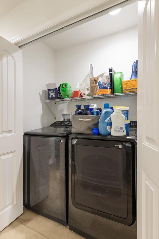 washroom with laundry area, light tile patterned floors, and independent washer and dryer