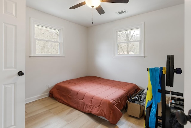 bedroom featuring multiple windows, light wood-type flooring, and visible vents