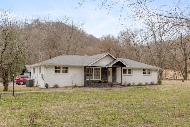 ranch-style house with central AC, a front lawn, a shingled roof, and brick siding