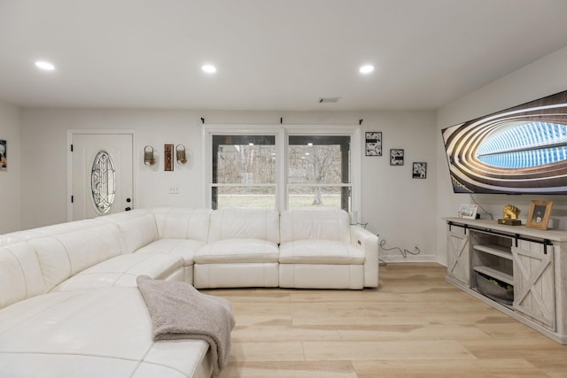 living area with baseboards, recessed lighting, and light wood-style floors