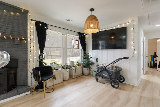 living area featuring baseboards, a fireplace, visible vents, and wood finished floors