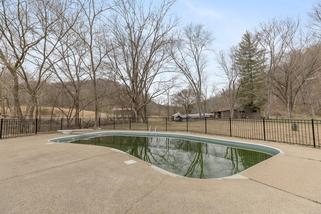 view of pool featuring a fenced in pool, a patio area, fence, and a diving board