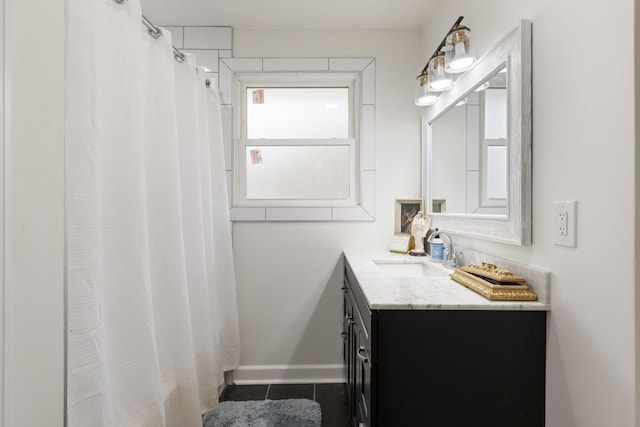 full bath featuring tile patterned flooring, baseboards, and vanity