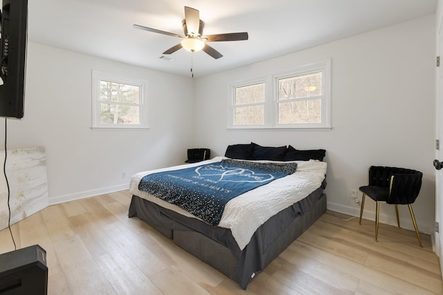 bedroom featuring ceiling fan, wood finished floors, visible vents, and baseboards