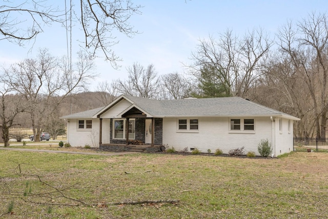 ranch-style home featuring roof with shingles, fence, a front lawn, and brick siding