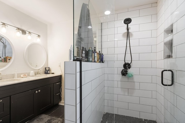 bathroom with double vanity, a shower stall, and a sink