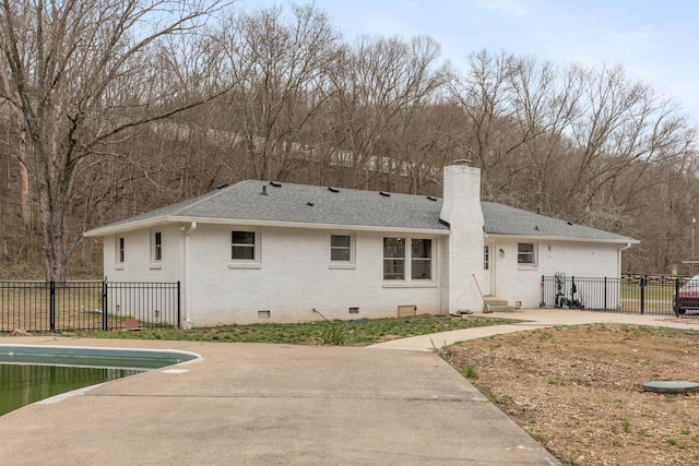 back of house featuring brick siding, fence, crawl space, a chimney, and a patio area