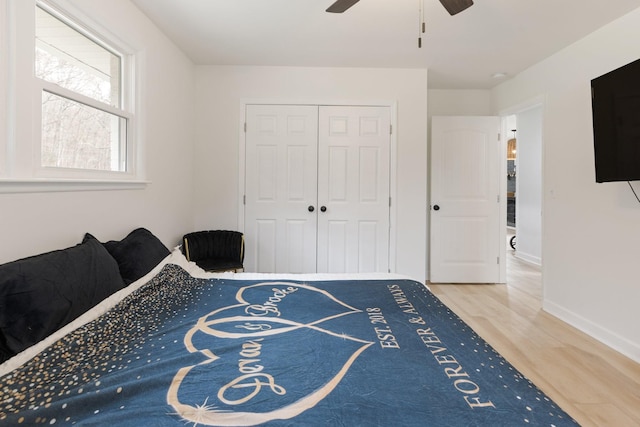 unfurnished bedroom featuring ceiling fan, a closet, wood finished floors, and baseboards