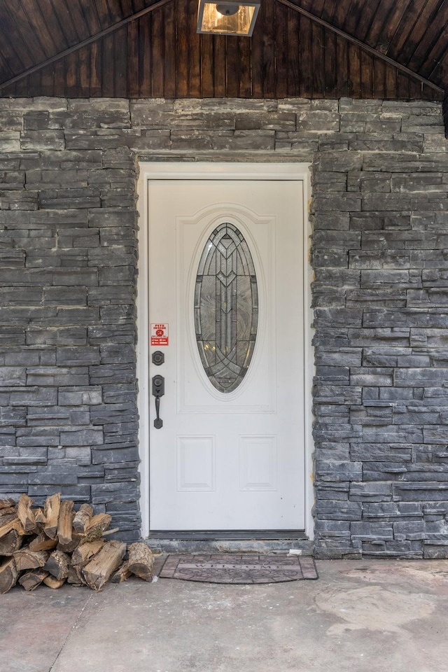 doorway to property featuring stone siding