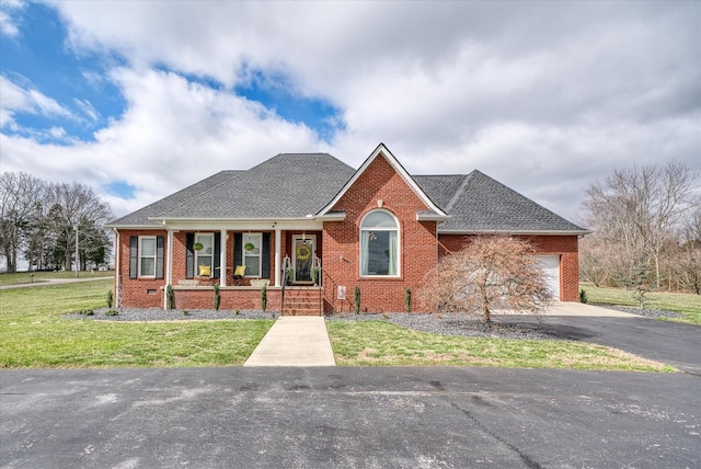 ranch-style home with covered porch, aphalt driveway, and brick siding