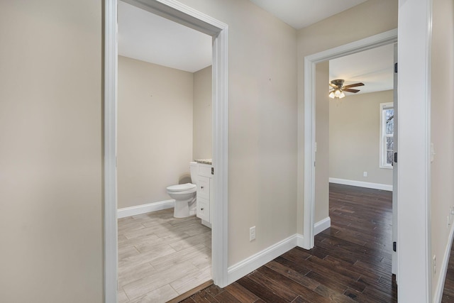 bathroom featuring vanity, wood finished floors, baseboards, and a ceiling fan