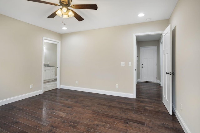 unfurnished bedroom with dark wood-type flooring, recessed lighting, baseboards, and connected bathroom