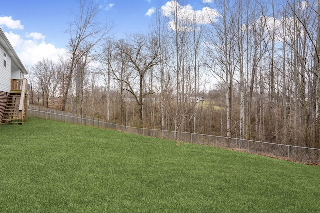 view of yard with stairway, a deck, and a fenced backyard