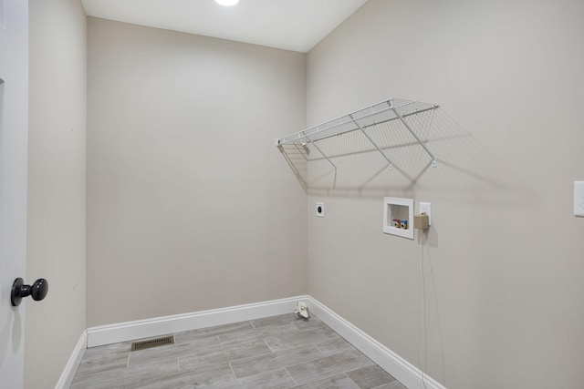 laundry room featuring electric dryer hookup, visible vents, washer hookup, baseboards, and laundry area