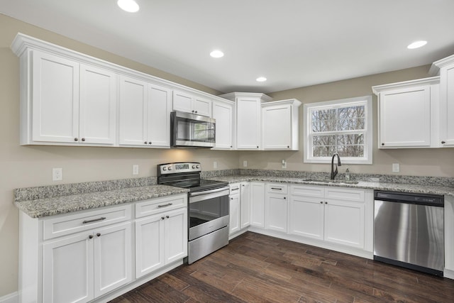 kitchen featuring recessed lighting, a sink, dark wood-type flooring, appliances with stainless steel finishes, and white cabinetry