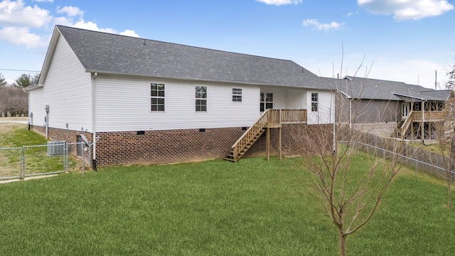 rear view of property featuring a shingled roof, fence, stairs, a yard, and a gate